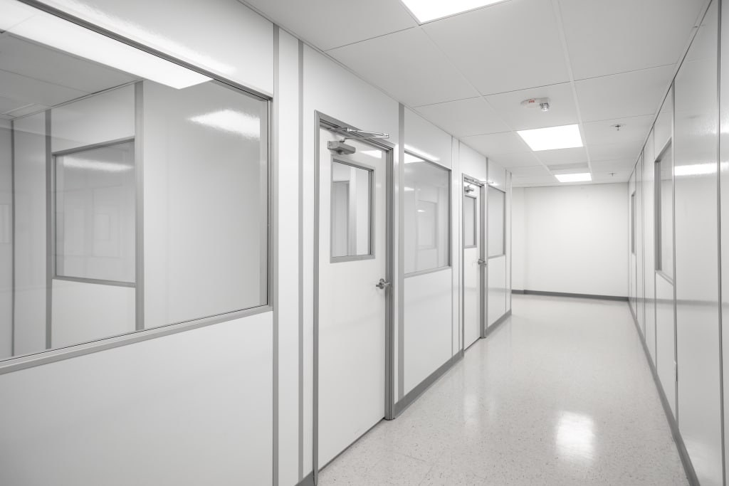 A bright, sterile hallway inside a modular hardwall cleanroom, featuring multiple doors and windows.