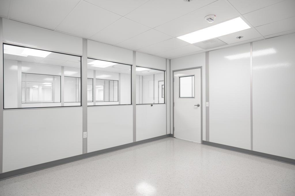 Cleanroom Design: An Introduction Interior view of a modular cleanroom by Allied Cleanrooms with clear observation windows and seamless white wall panels.