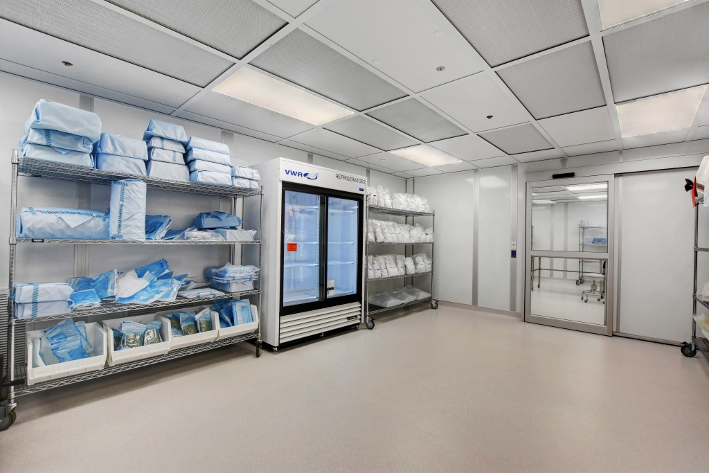 Modular Class 10000 cleanroom by Allied Cleanrooms, featuring clean shelving, packaged supplies, and ceiling-mounted HEPA filtration.