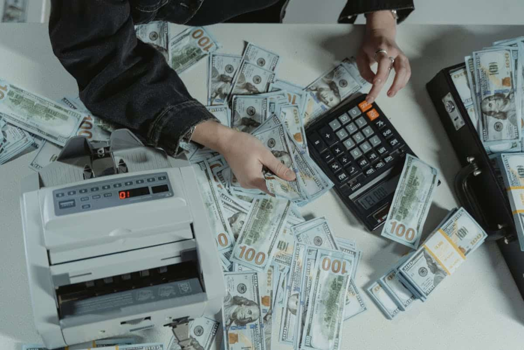7 Key Advantages of Modular Aerospace Cleanrooms A table with money, money-counting equipment, and a calculator.