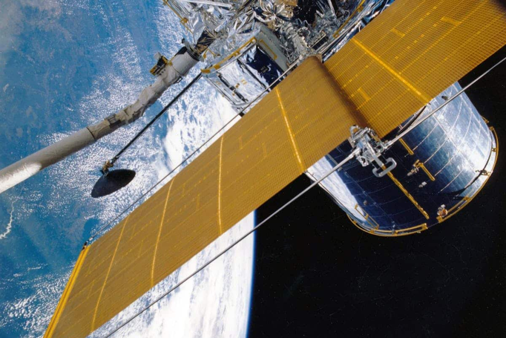 7 Key Advantages of Modular Aerospace Cleanrooms A satellite hangs over Earth.