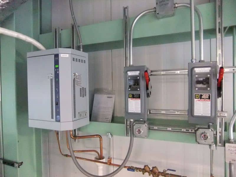 What are Pharmaceutical Cleanrooms? The Ultimate Guide Electrical control panel and manual disconnect switches mounted on a wall with conduits and copper piping in a cleanroom utility area.