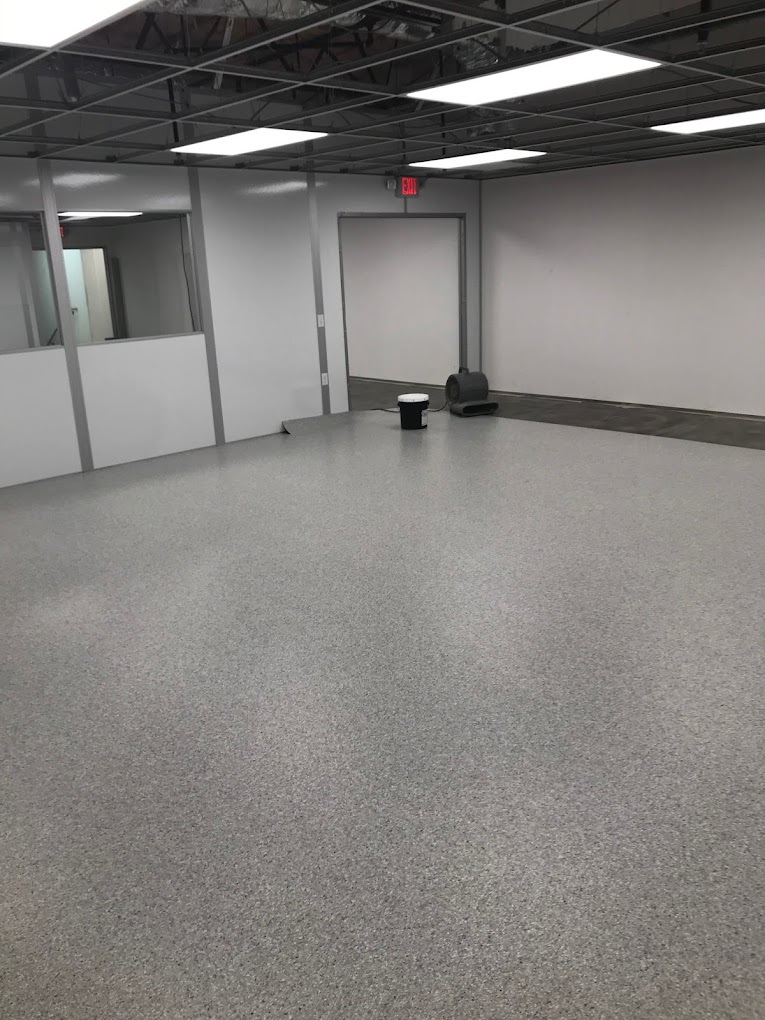 Cleanroom Checklist: Steps to Successful Design An empty cleanroom with cleanroom flooring, exposed ceiling beams, and fluorescent lighting.