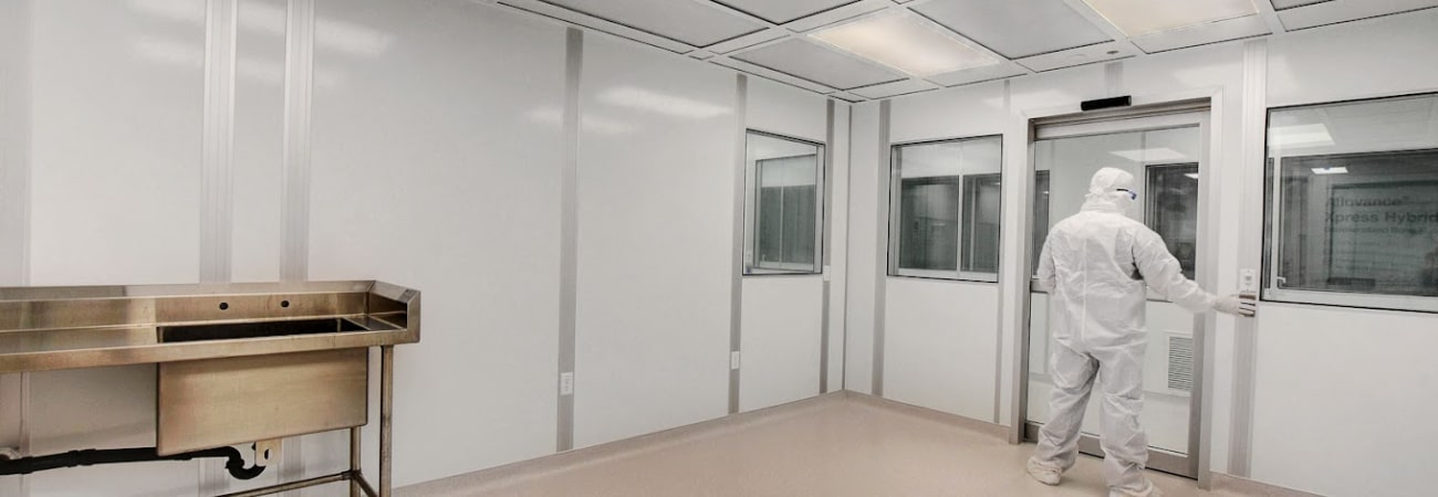 A man in gowning works in an ISO 4 cleanroom by Allied Modular.