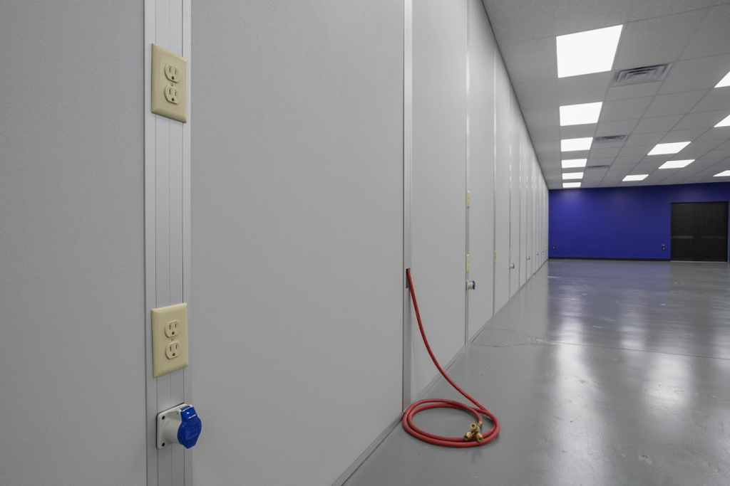 Food Processing Cleanrooms: Benefits, Features, and Uses Cleanroom walls with integrated electrical outlets and utility connections in a controlled environment by allied cleanrooms modular cleanroom design