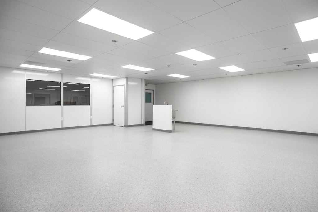 USP 797 Cleanrooms: Definition, Requirements, and Design A clean, empty climate-controlled room with bright overhead lighting and smooth, sterile flooring.