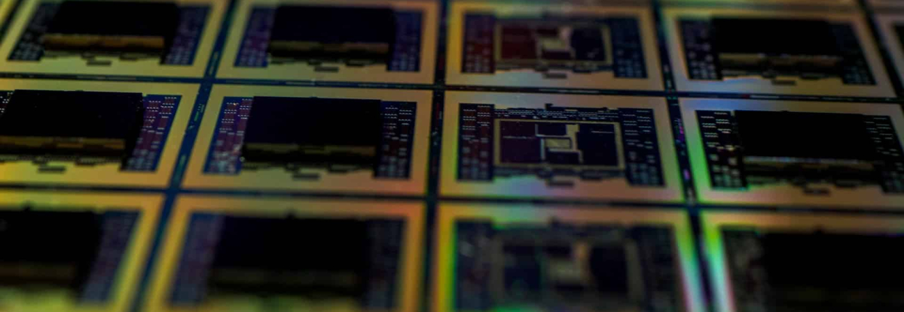 Close-up of semiconductor wafers manufactured in semiconductor cleanrooms with intricate circuit patterns.