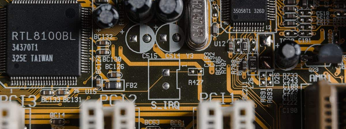 Close-up view of an electronic circuit board showcasing intricate components and connections, highlighting the precision and cleanliness required in electronics manufacturing.
