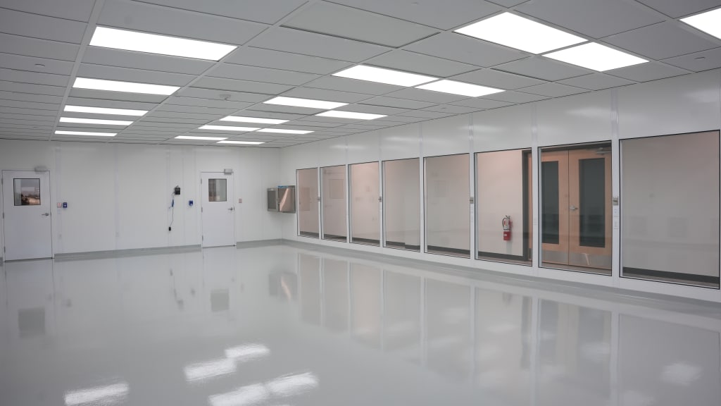 How Long Does Building a Modular Cleanroom Take? Spacious modular cleanroom with white wall panels, large viewing windows, and overhead lighting, built by Allied Cleanrooms.
