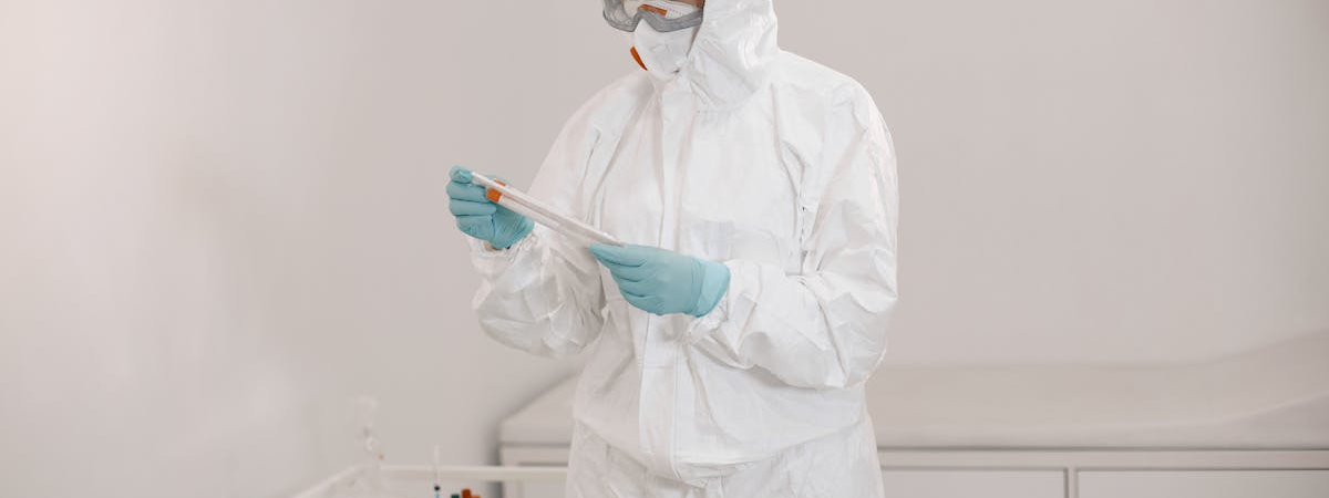 Technician in full protective suit performing cleanroom testing at an Allied Cleanrooms facility.