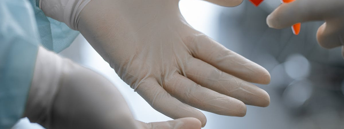 Gloved hands being sanitized as part of cleanroom maintenance at Allied Cleanrooms