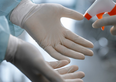 Gloved hands being sanitized as part of cleanroom maintenance at Allied Cleanrooms